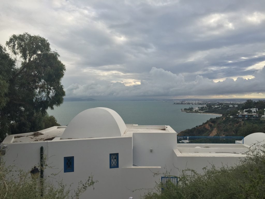 A white building in Sidi Bou Said, with the ocean behind it