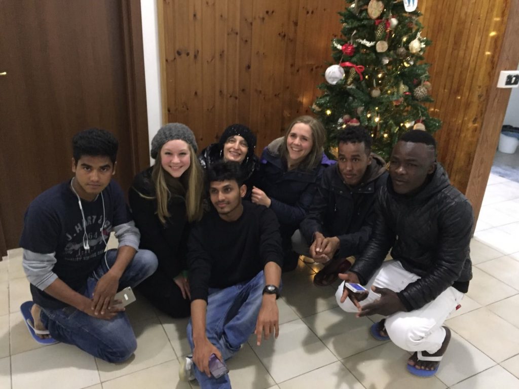 Seven people pose by a Christmas tree