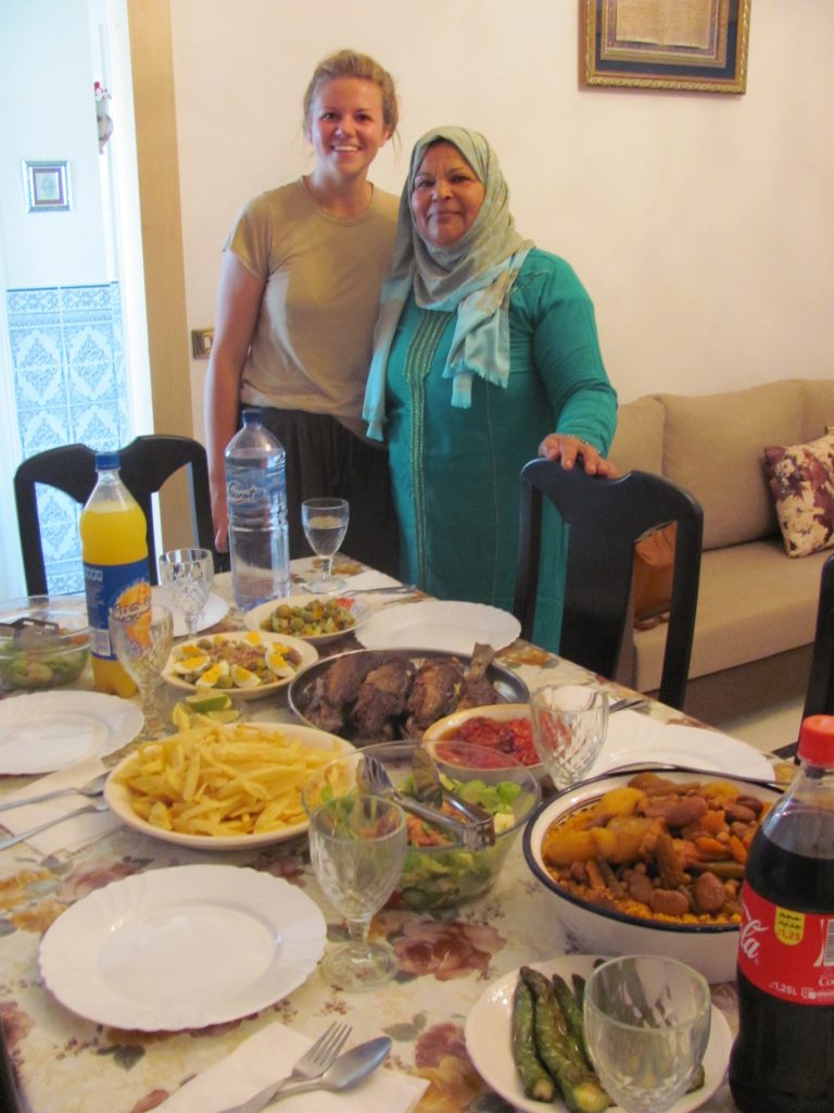 Two women standing behind a table crowded with food