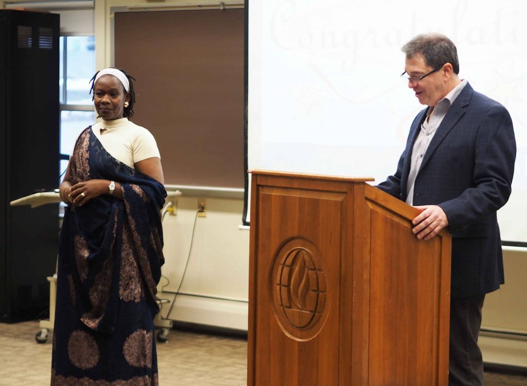 Female student listens as her professor talks about her achievements