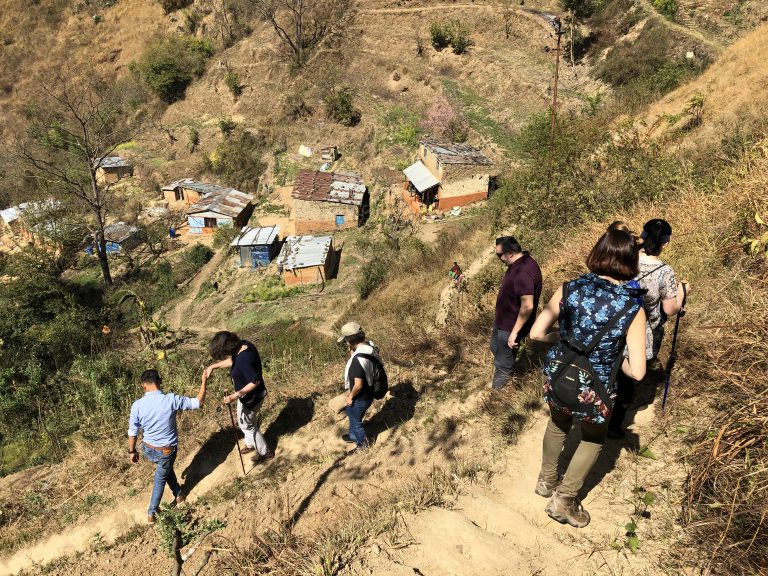 Men and women walking down a steep mountain trail