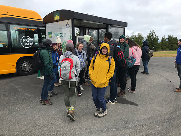 A group of students prepares to board a methane-powered bus.