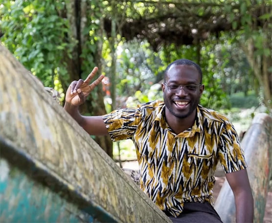 Kwabena holds up two fingers in a peace sign.