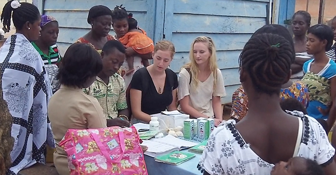 SIT students and Ghanaian students sit at a table