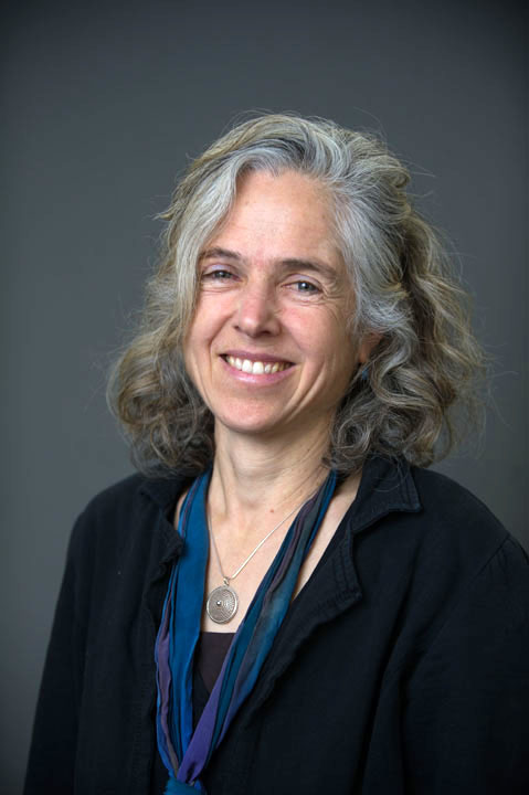 A woman with shoulder-length salt-and-papper hair smiles broadly.