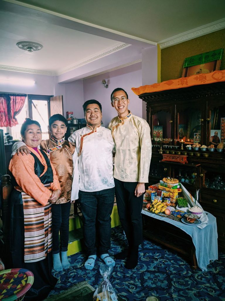 A family of three people and the study abroad student in a Nepali home