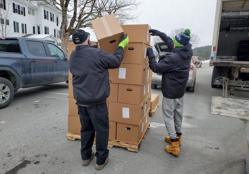 Volunteers stack boxes during a distribution event on the Vermont campus in January 2021.