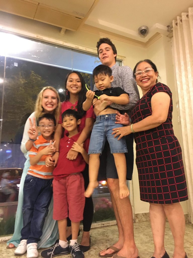 Two U.S. students with a Vietnamese family, including three young boys, a teen and their mother