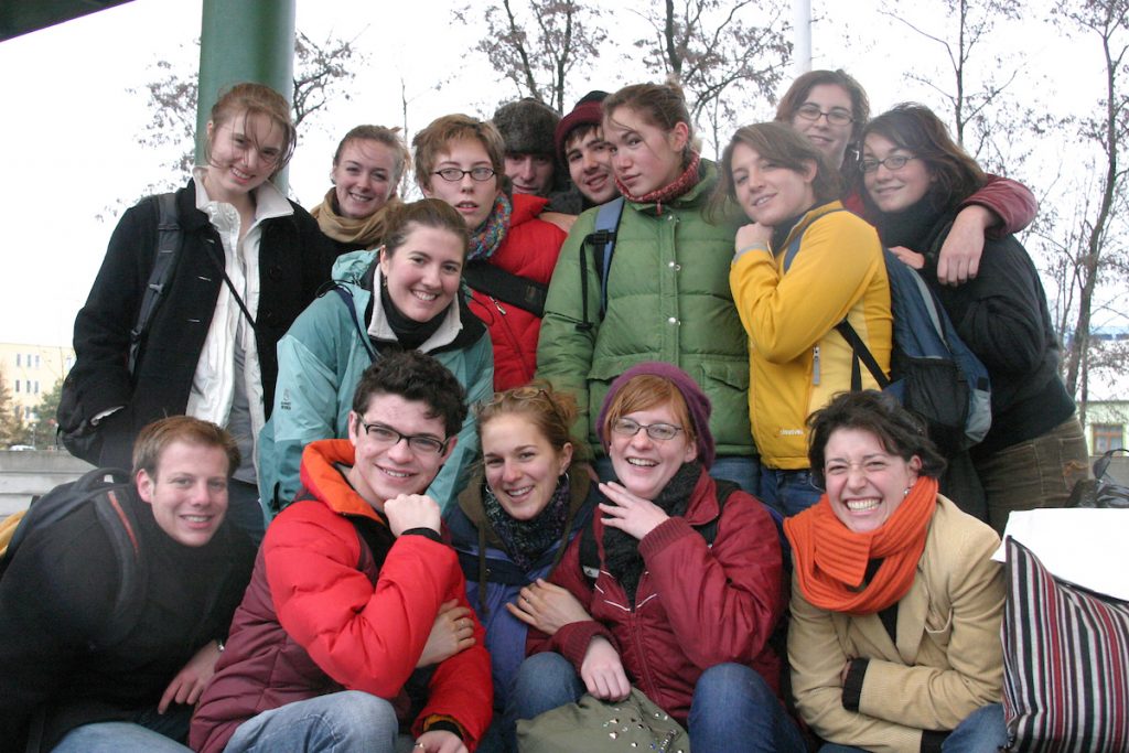Fifteen young people smile toward the camera. All appear to be white.