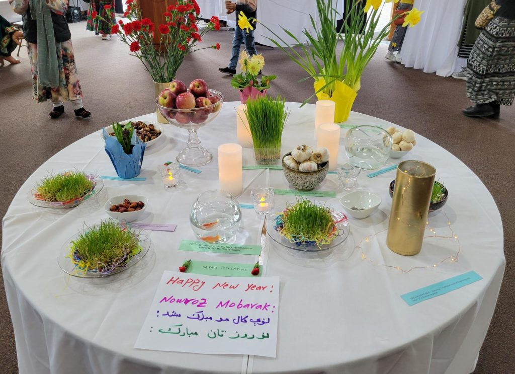 A table with grasses, flowers, nuts garlic, candles, vinegar and goldfish