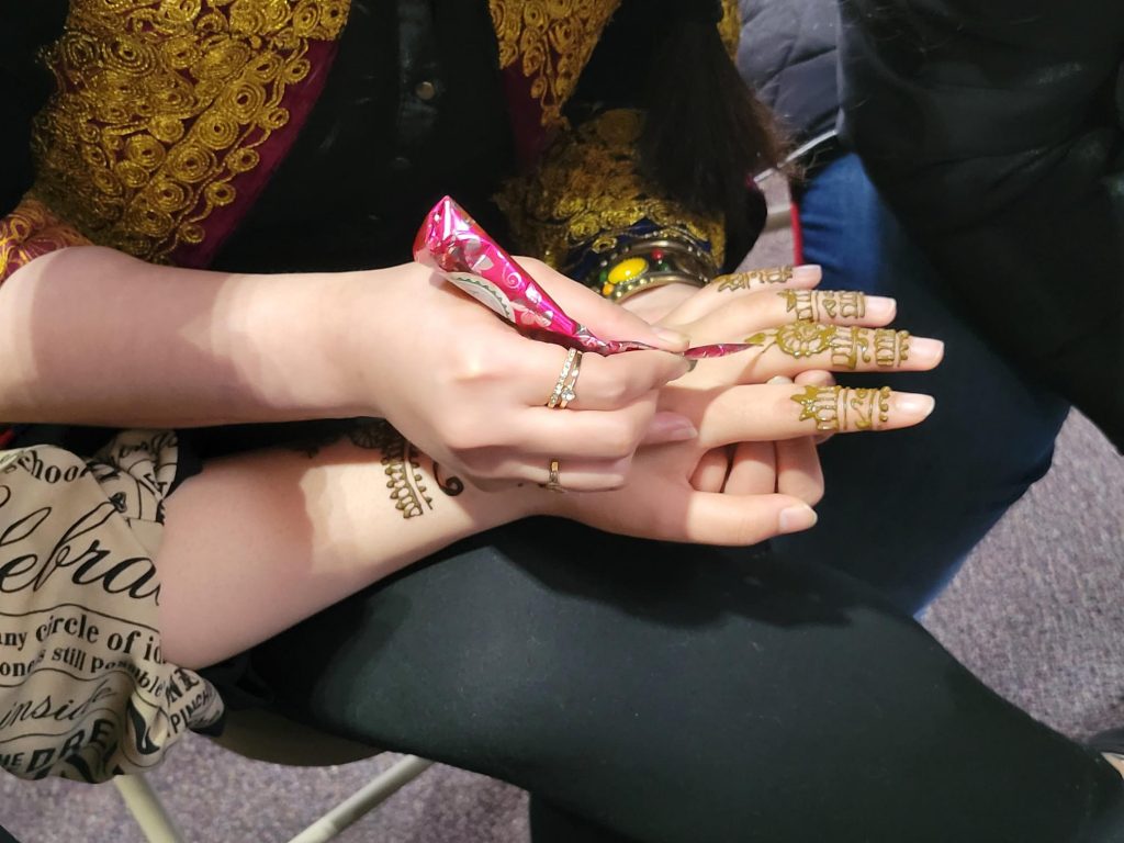 Hands being painted with decorative patterns in hanna