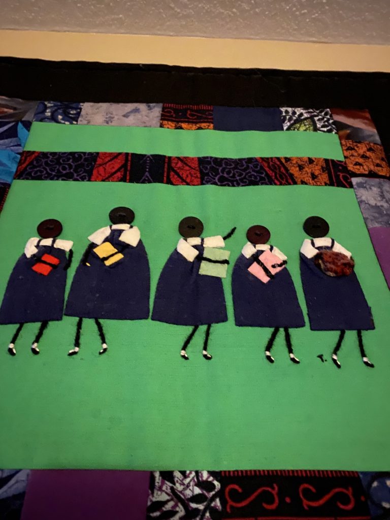 A quilt square showing African woman on a green background