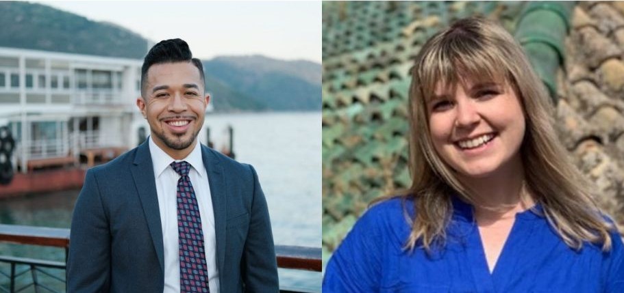 On the left side, a young man with black hair and a goatee wearing a suit and tie; on the right, a young woman with blonde hair and a blue blouse.