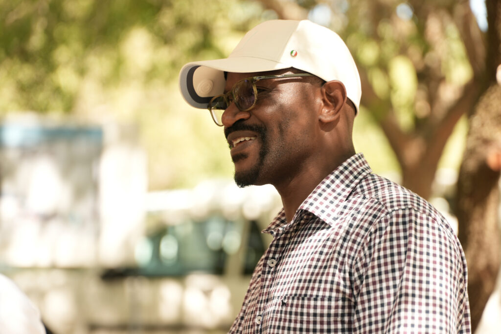 A Black man wearing sunglasses and a white baseball cap.