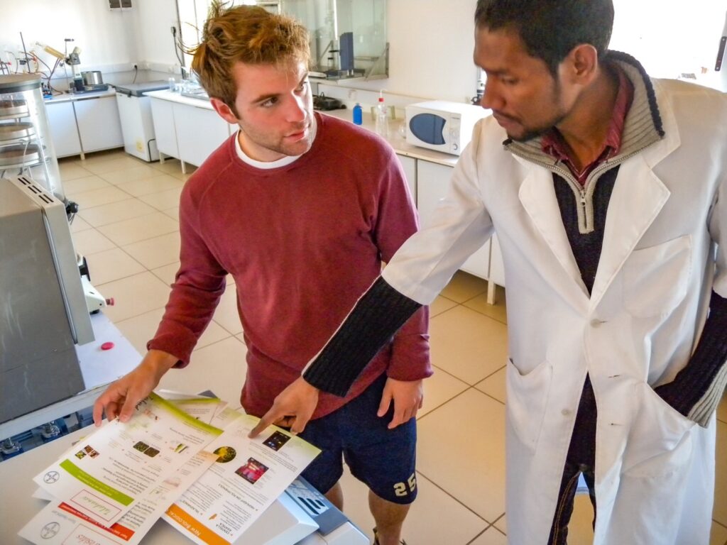 A student and a teacher in a science lab review materials.