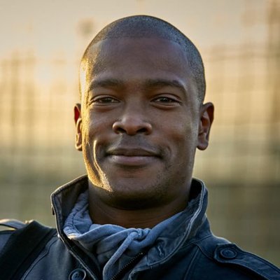 A close-up of a South African man smiling at the camera.